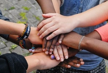 Multiracial,Teenagers,Joining,Hands,Together,In,Cooperation