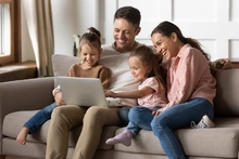 Happy,Family,With,Two,Little,Daughters,Using,Laptop,Together,,Sitting